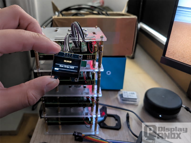 Raspberry Pi OLED display module showing system information in a real hardware setup